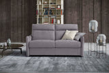 A premium, compact 2.5 seater Italian high-back sofa shown from an angle in light grey fabric in a roomset
